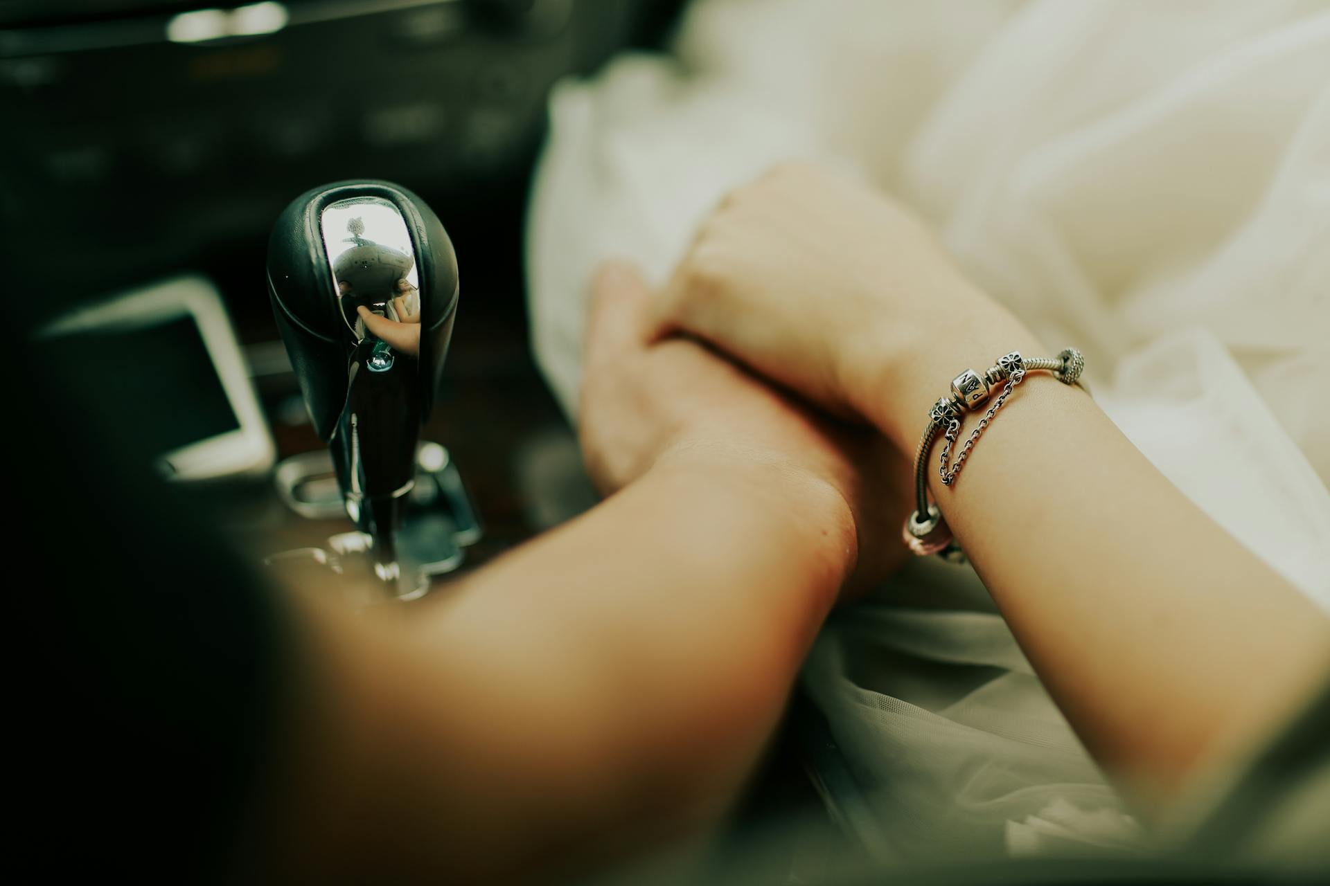 A woman holding a man's hand while seated in their car | Source: Pexels