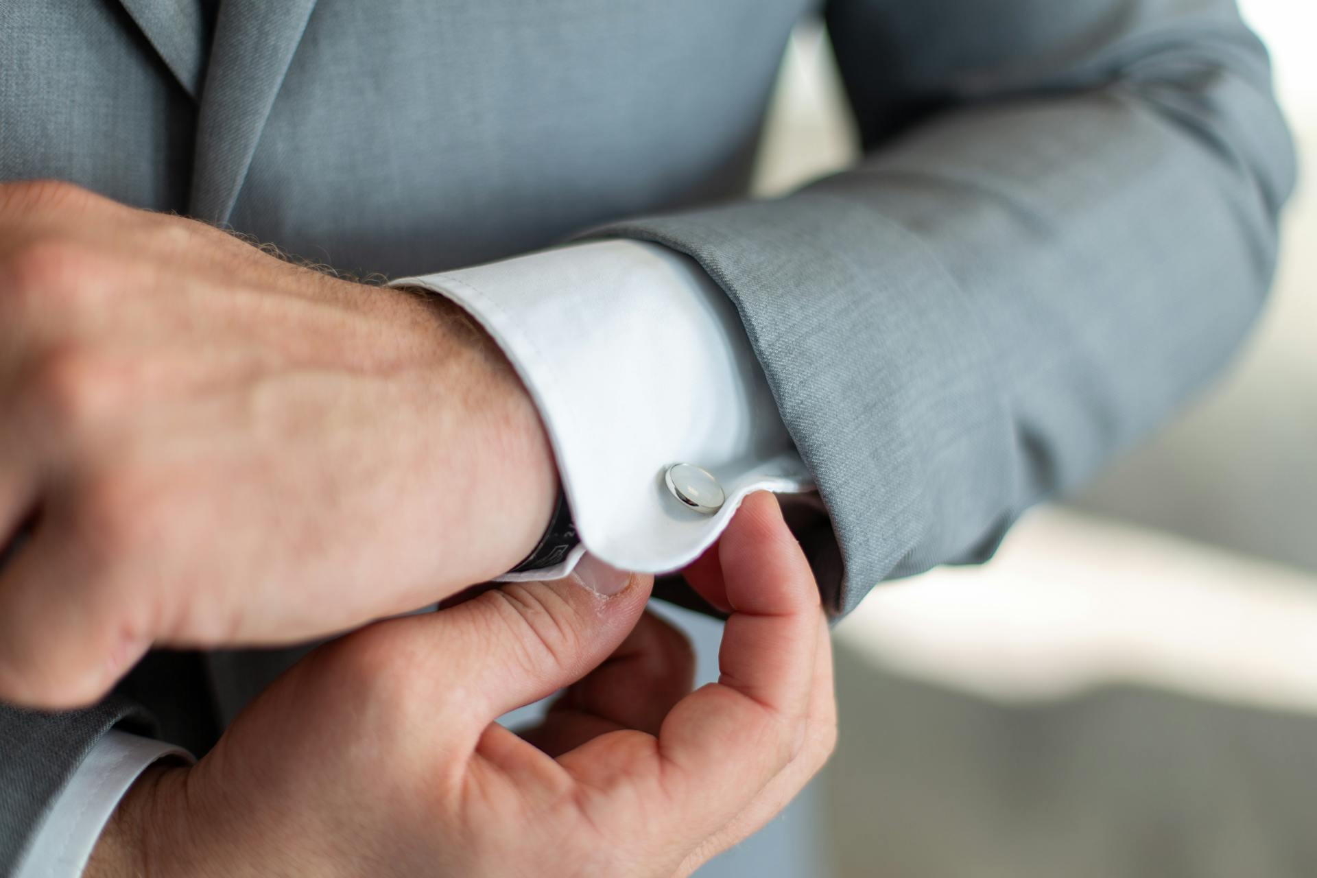 A man adjusting his cufflink | Source: Pexels
