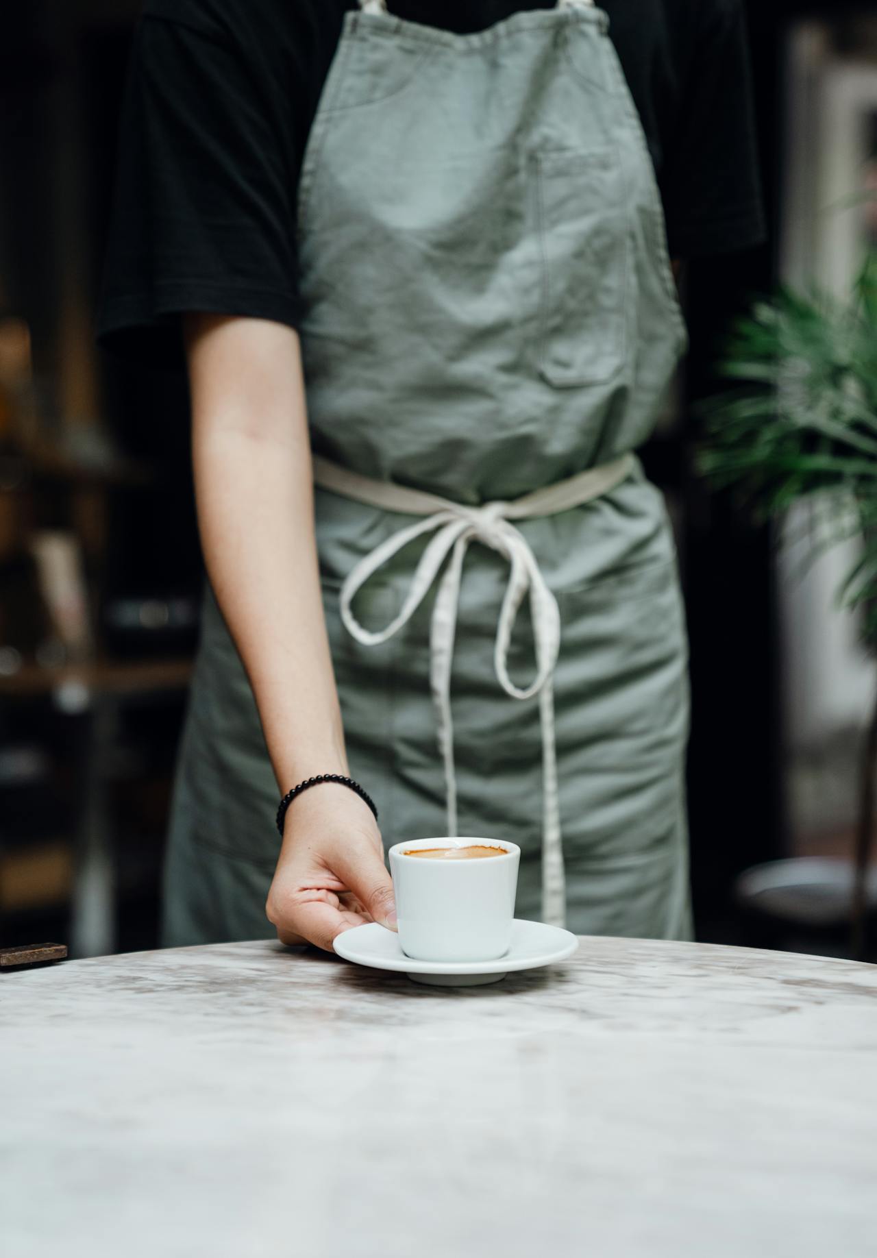 Uma garçonete colocando uma xícara de café na mesa | Fonte: Pexels