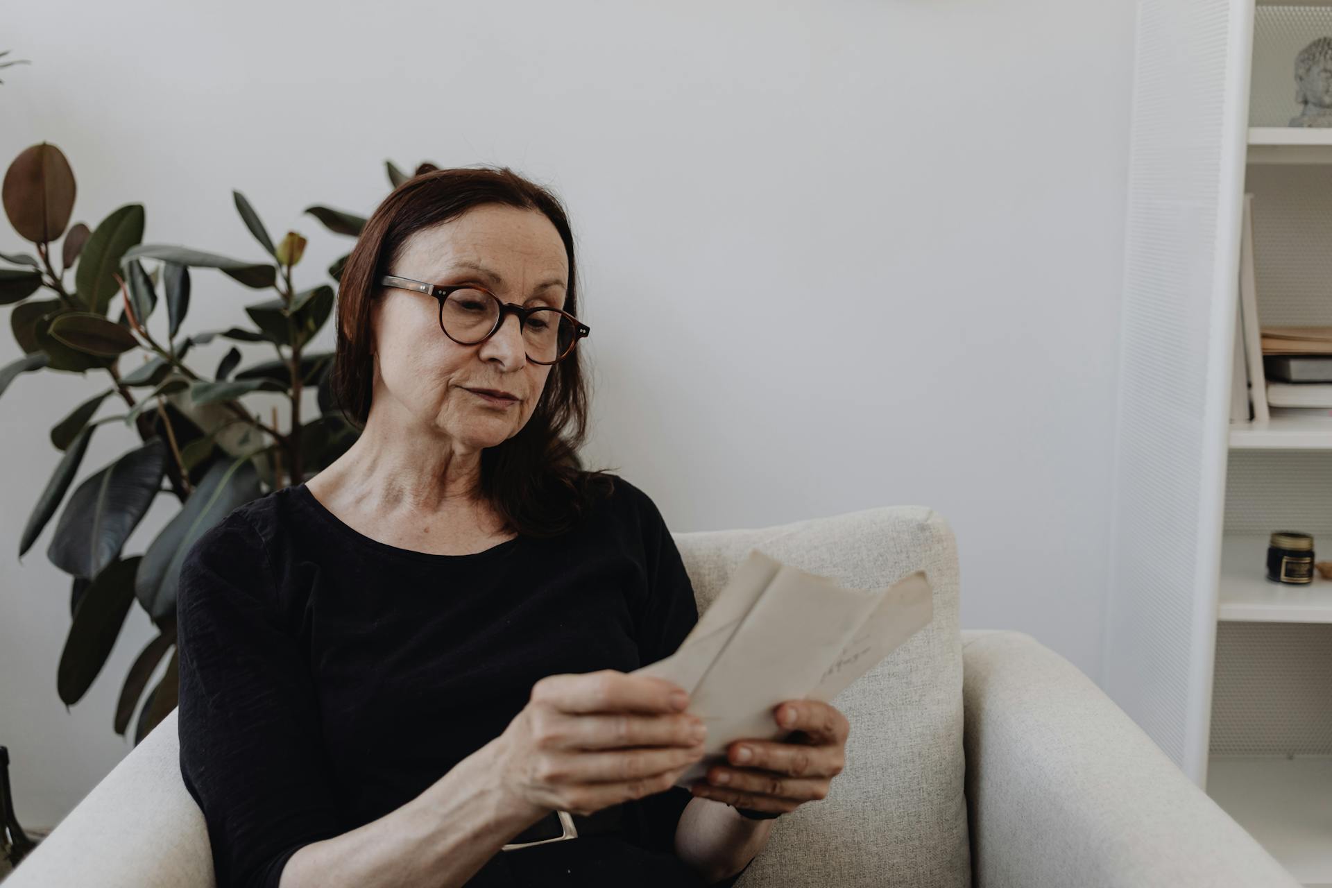 A woman staring longingly at photographs | Source: Pexels