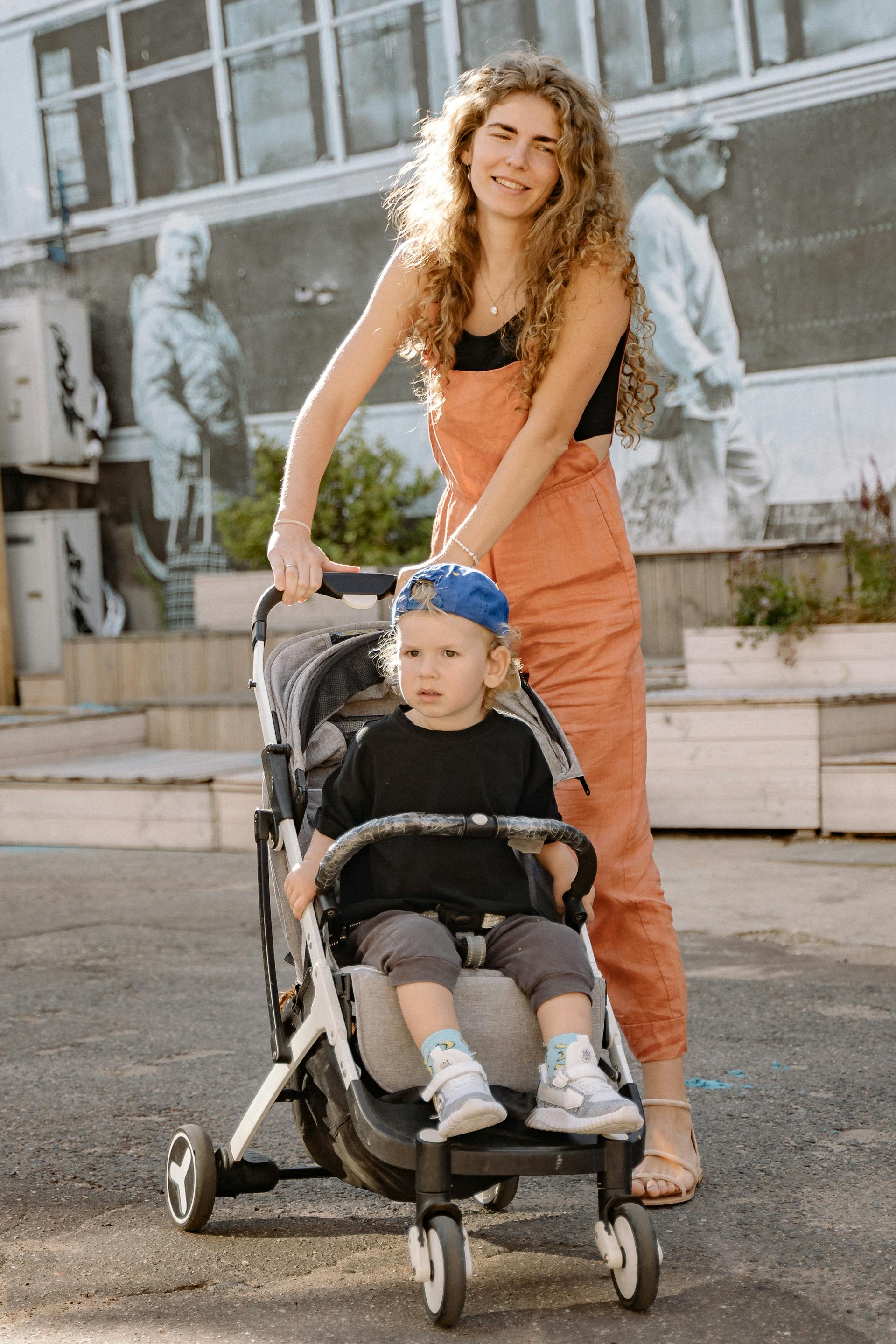 A woman pushing a stroller with her son in it | Source: Pexels