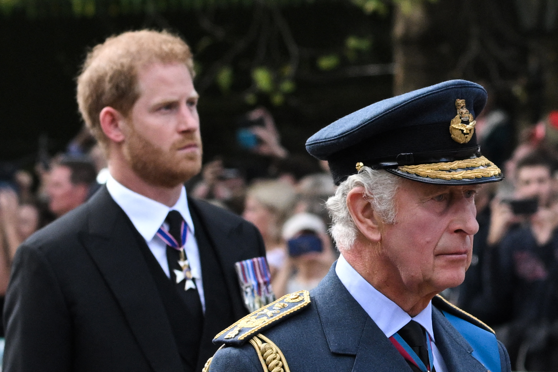King Charles III and Prince Harry, Duke of Sussex walk behind the coffin of Queen Elizabeth II, adorned with a Royal Standard and the Imperial State Crown and pulled by a Gun Carriage of The King's Troop Royal Horse Artillery, during a procession from Buckingham Palace to the Palace of Westminster, in London on September 14, 2022. | Source: Getty Images