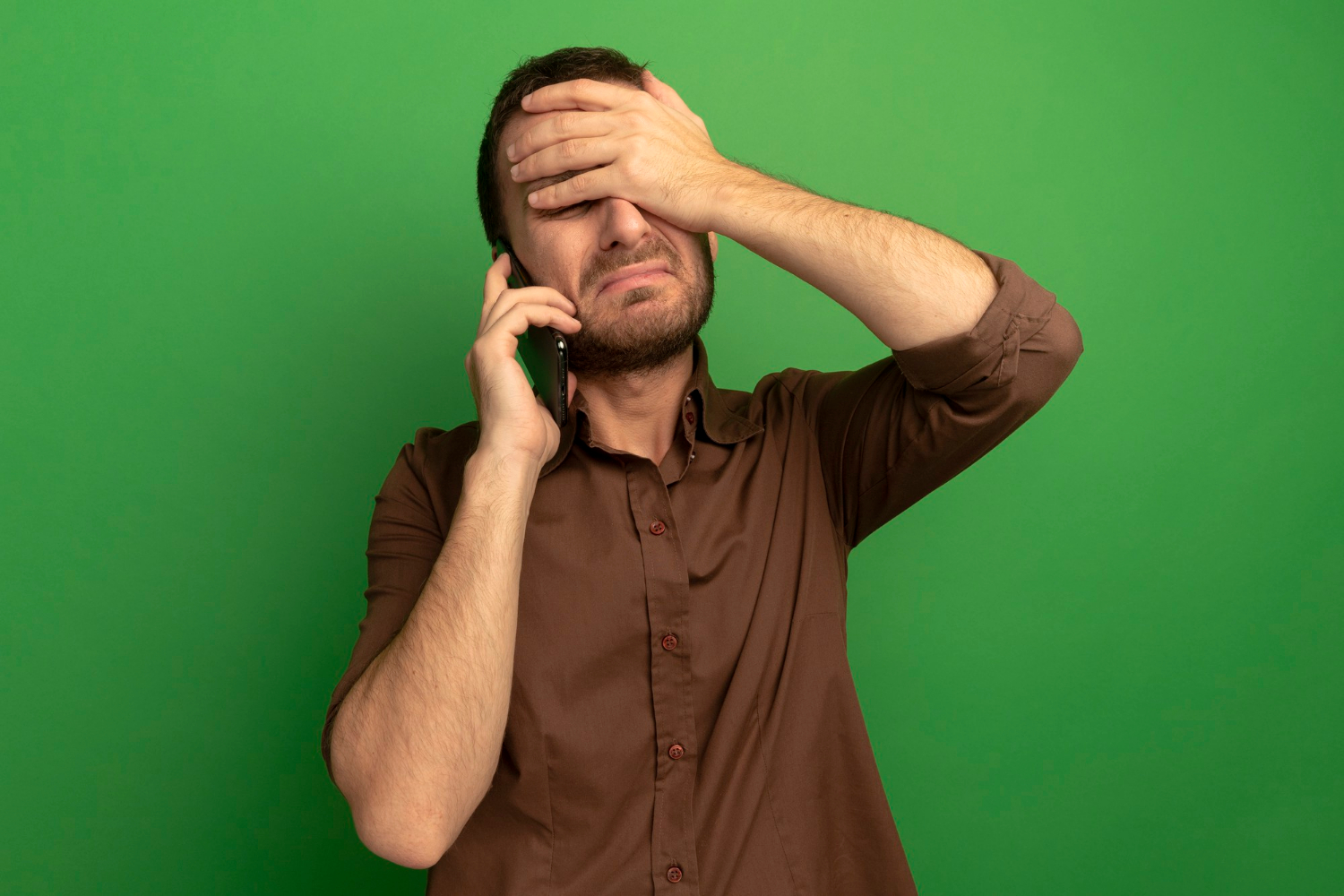 A shaken man sobbing while engaged on a phonecall | Source: Freepik