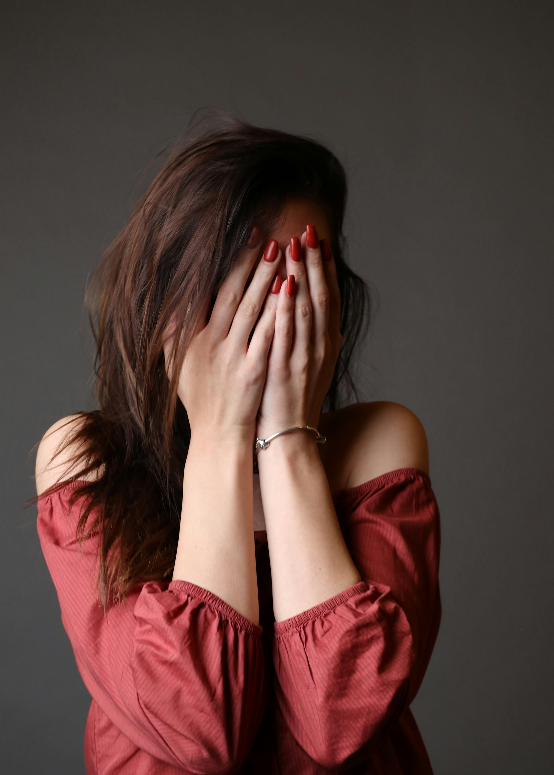 A woman covering her face with her hands | Source: Pexels