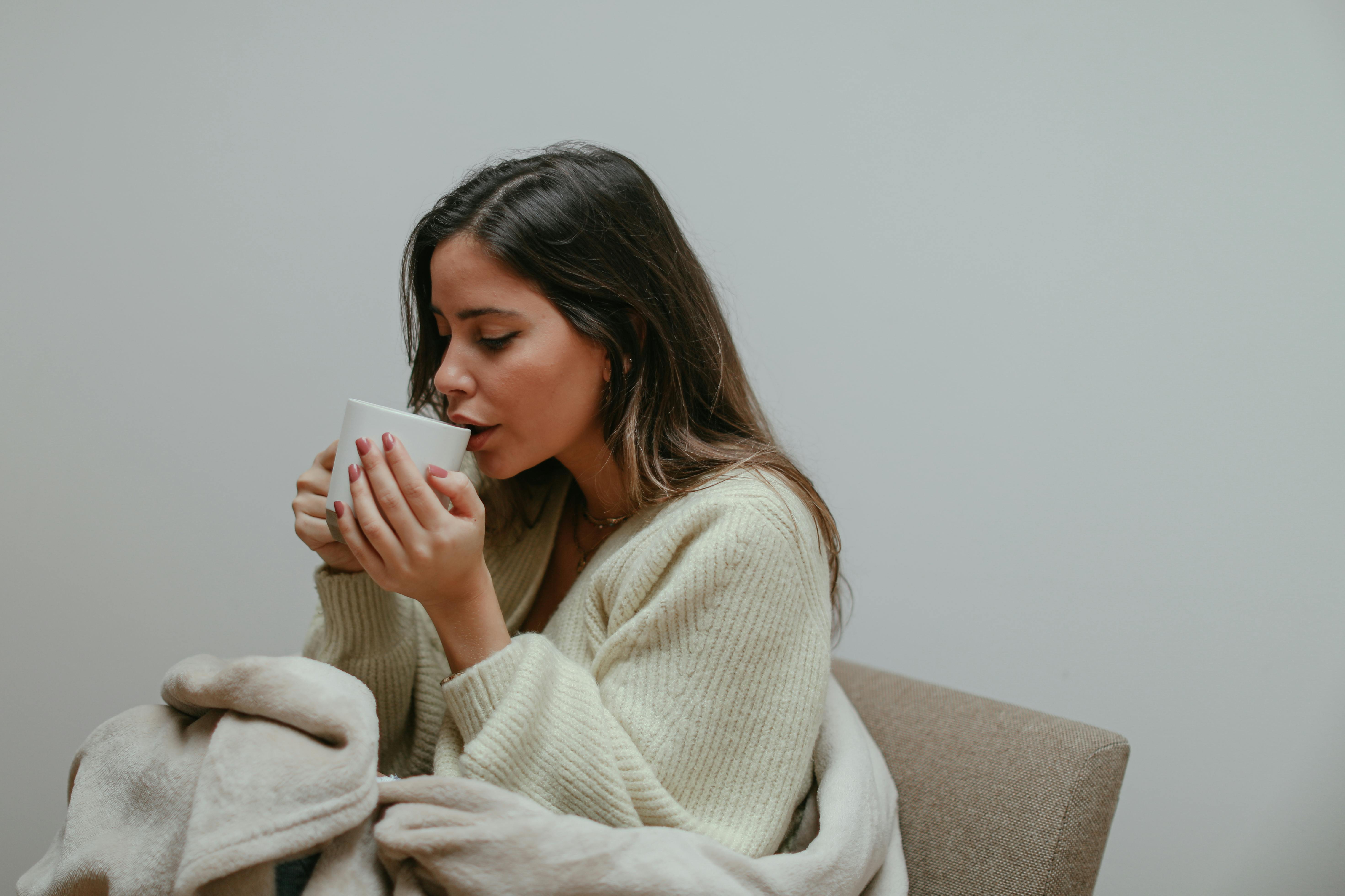 A woman sipping on her cup of tea | Source: Pexels