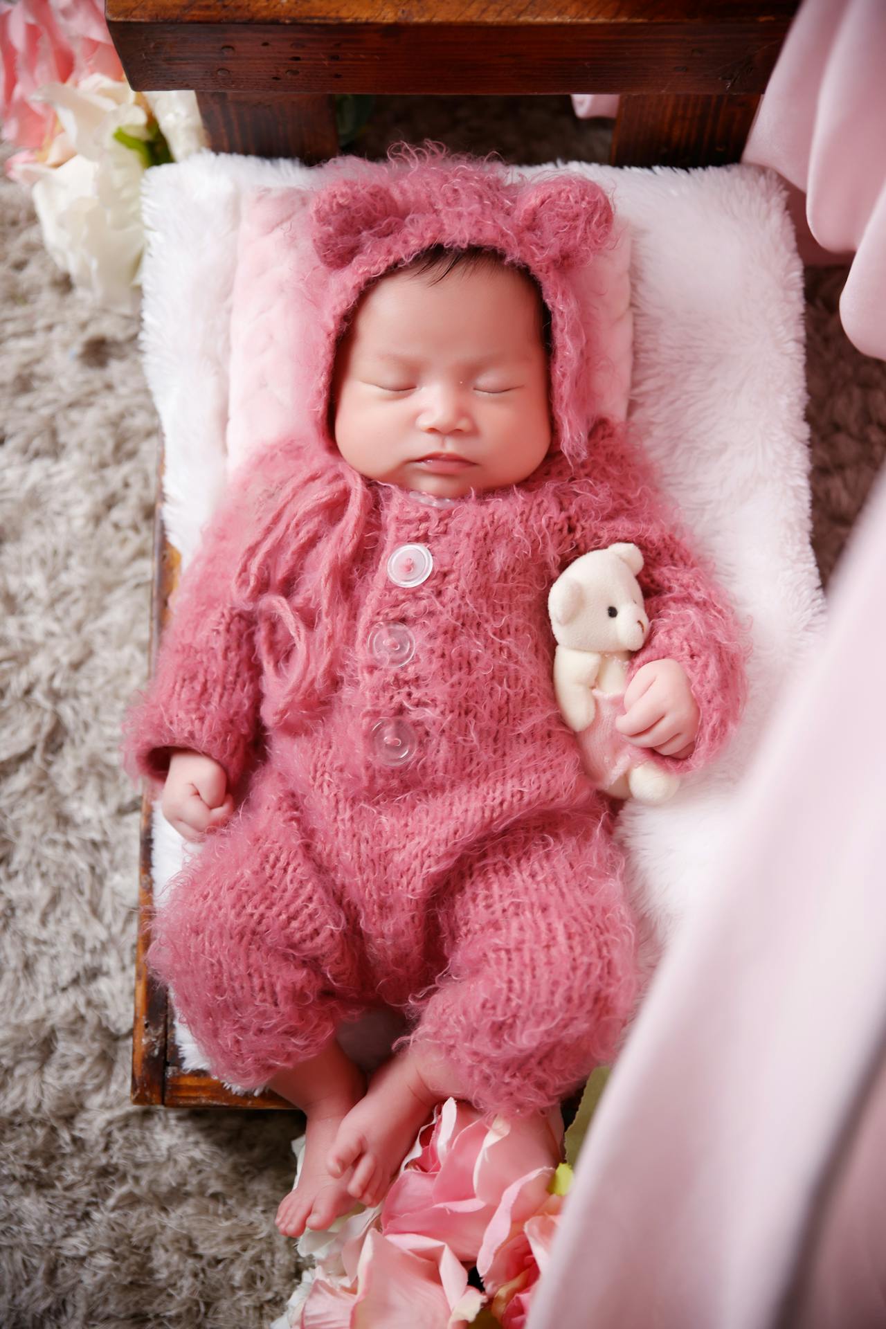 An adorable baby fast asleep hugging a teddy bear | Source: Pexels