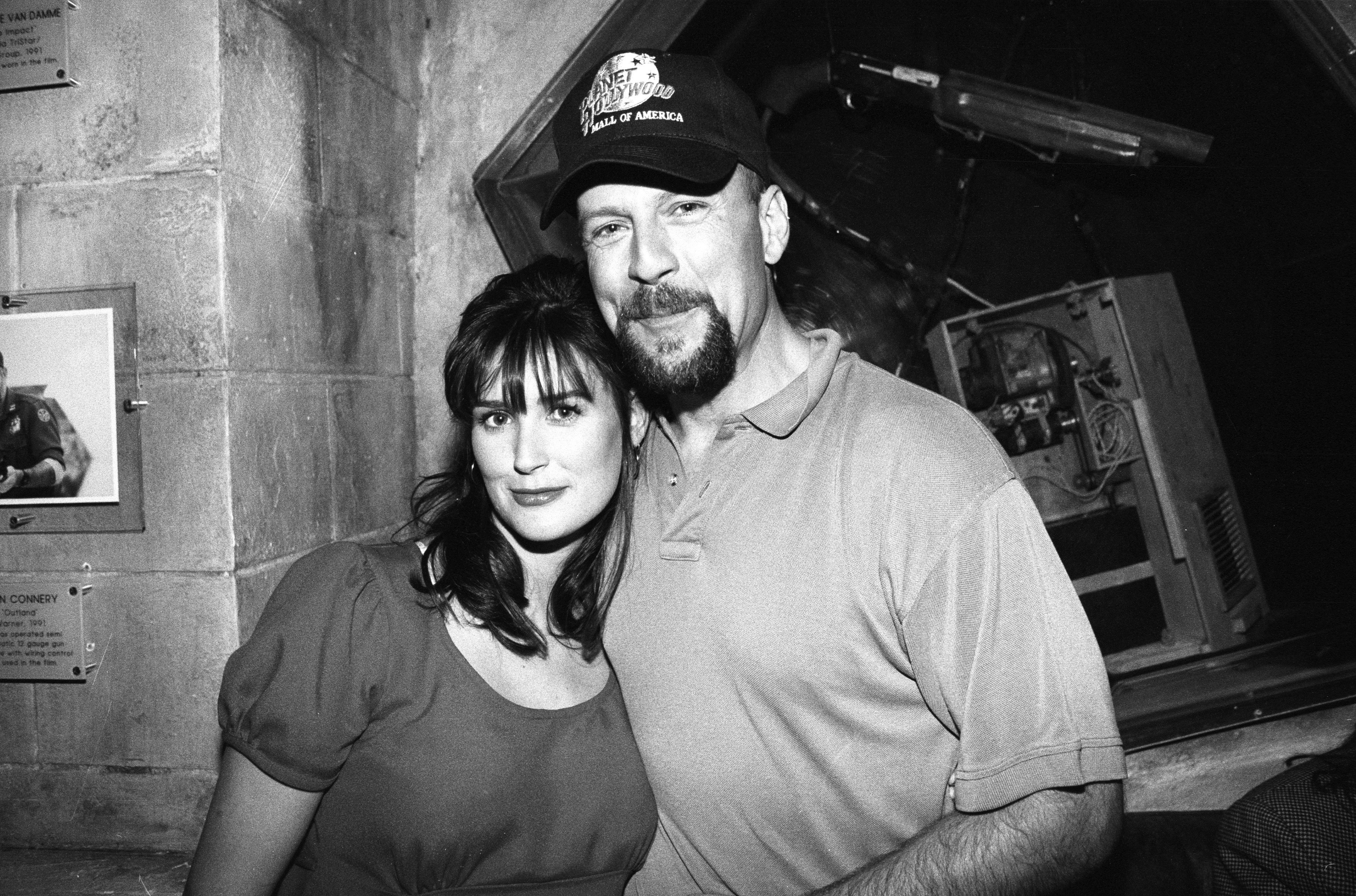 Demi Moore and Bruce Willis pose for a portrait at the opening of Planet Hollywood at the Mall of America on December 12, 1993, in Bloomington, Minnesota. | Source: Getty Images