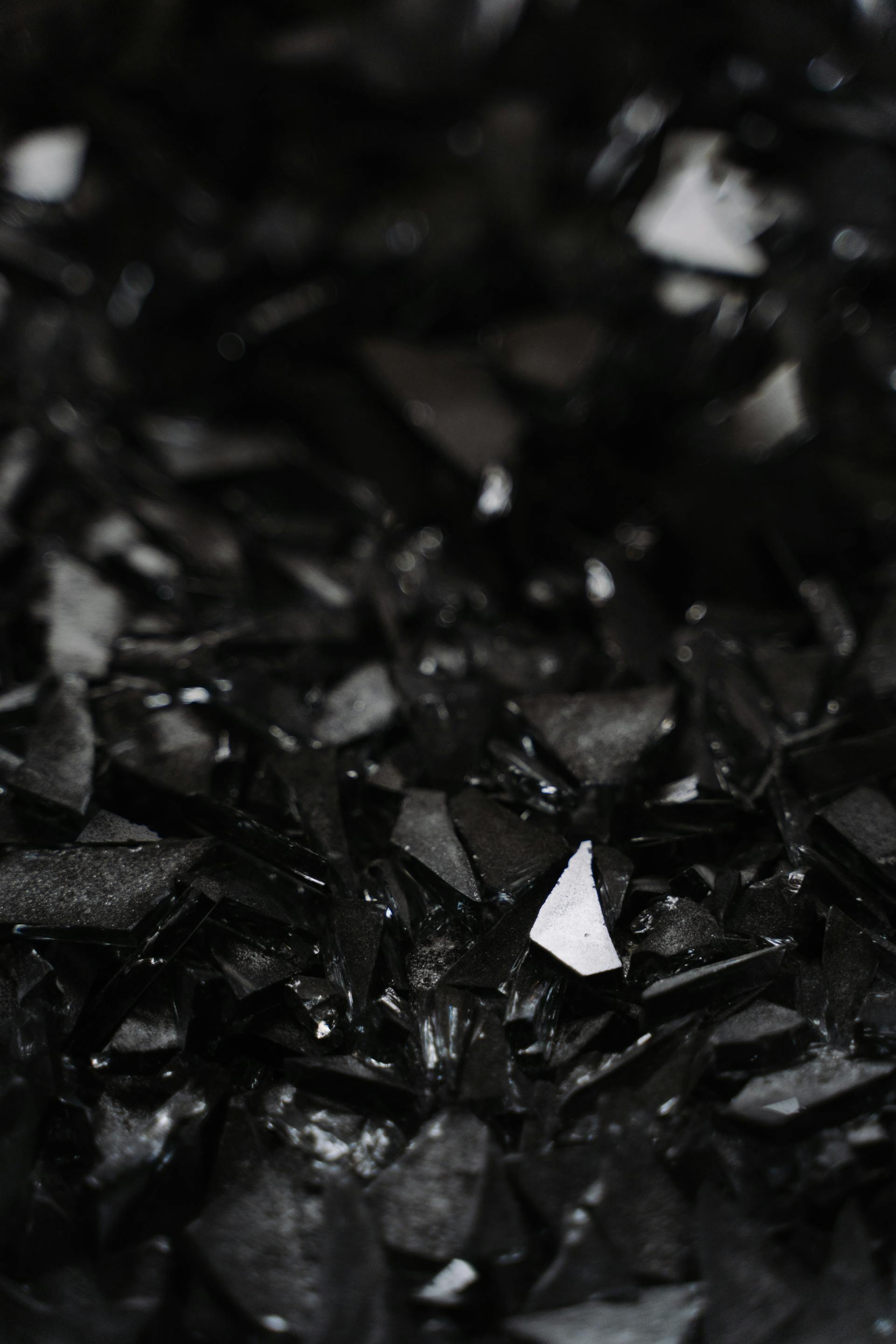 A grayscale photo of broken glass pieces on the ground | Source: Pexels