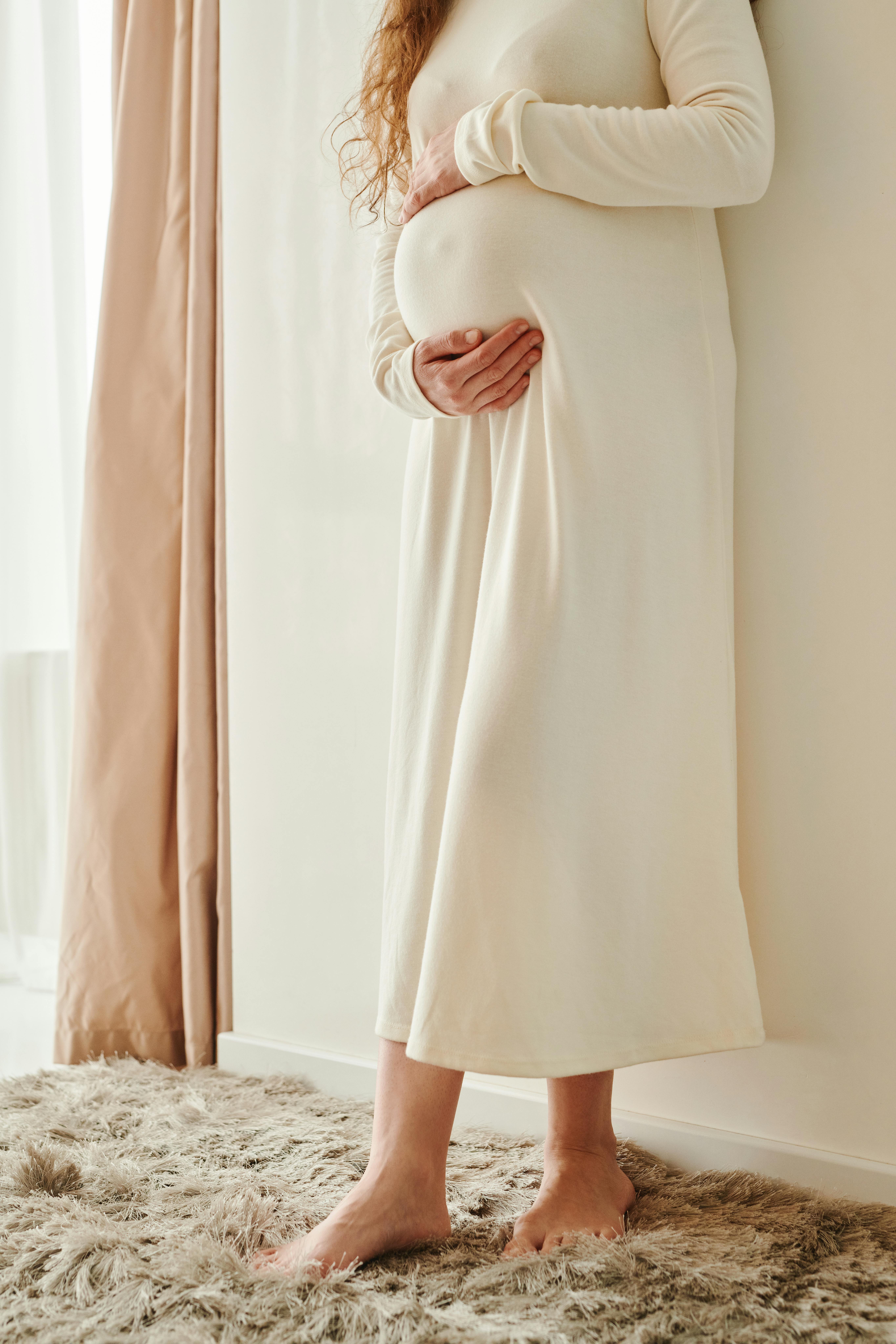 A pregnant woman cradling her tummy | Source: Pexels