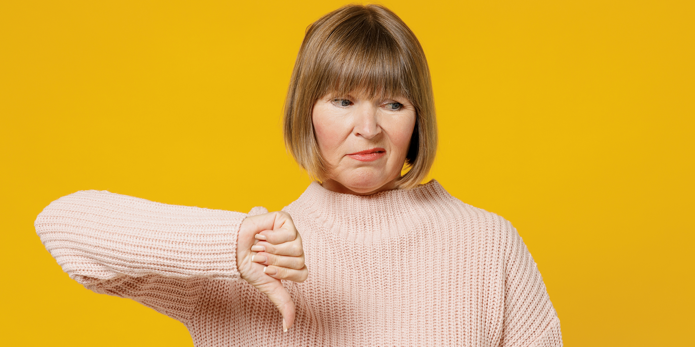 An unhappy woman giving a thumbs down sign | Source: Shutterstock