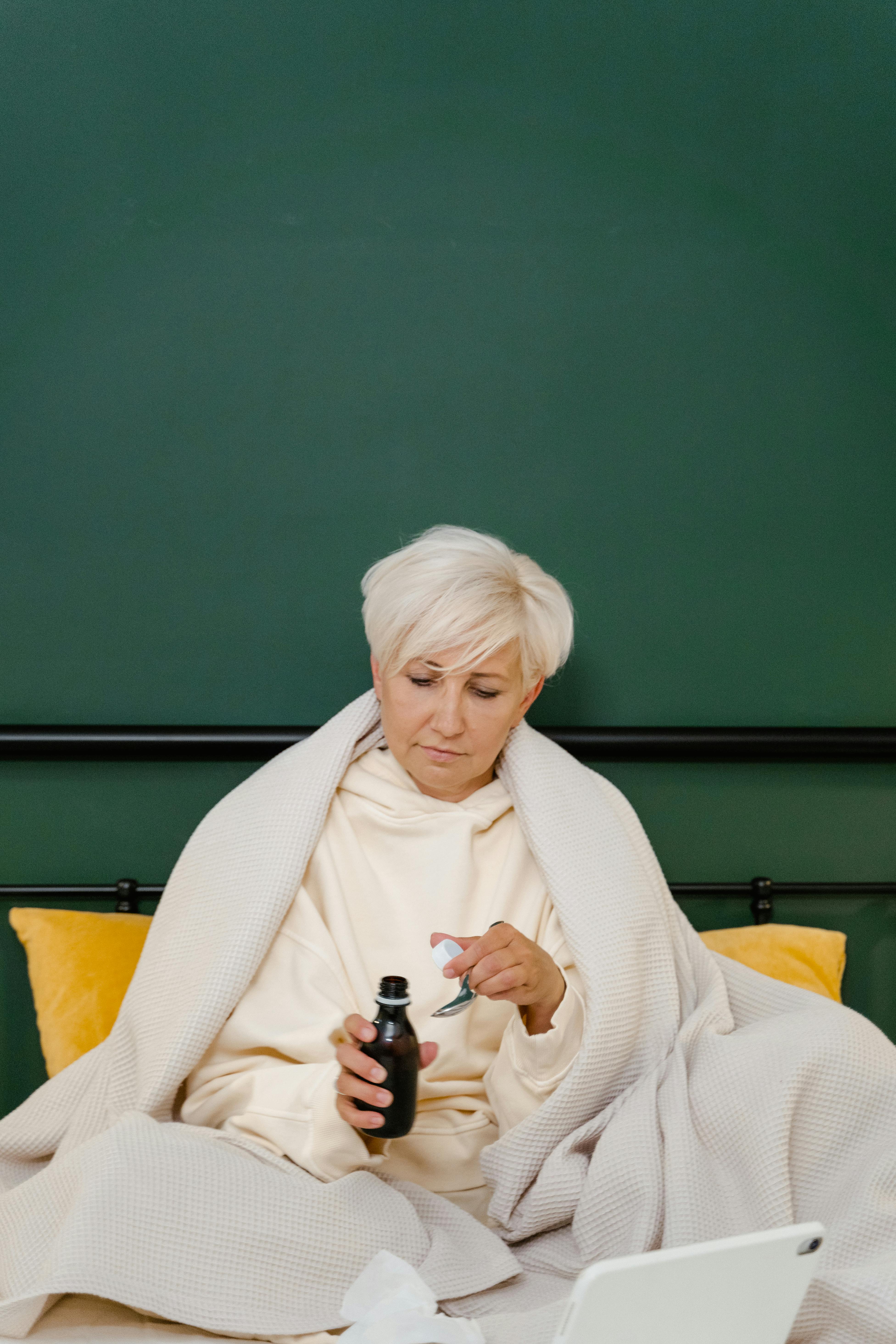 A woman talking medicine in bed | Source: Pexels