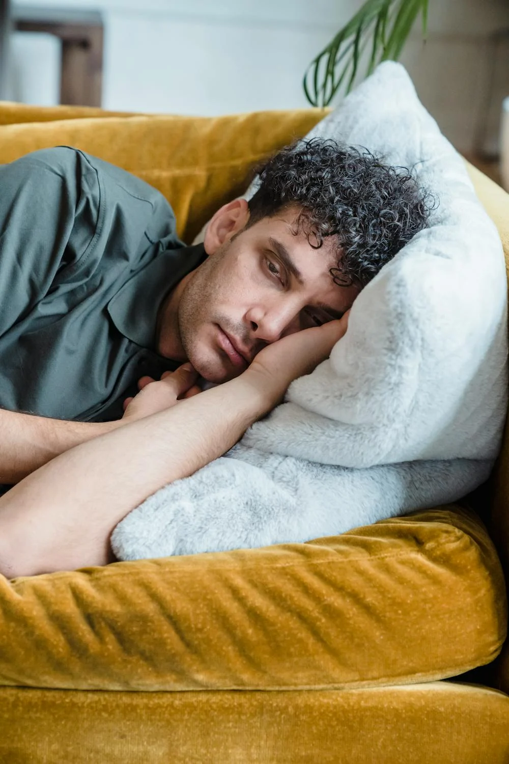 A sad tired man on a couch | Source: Pexels