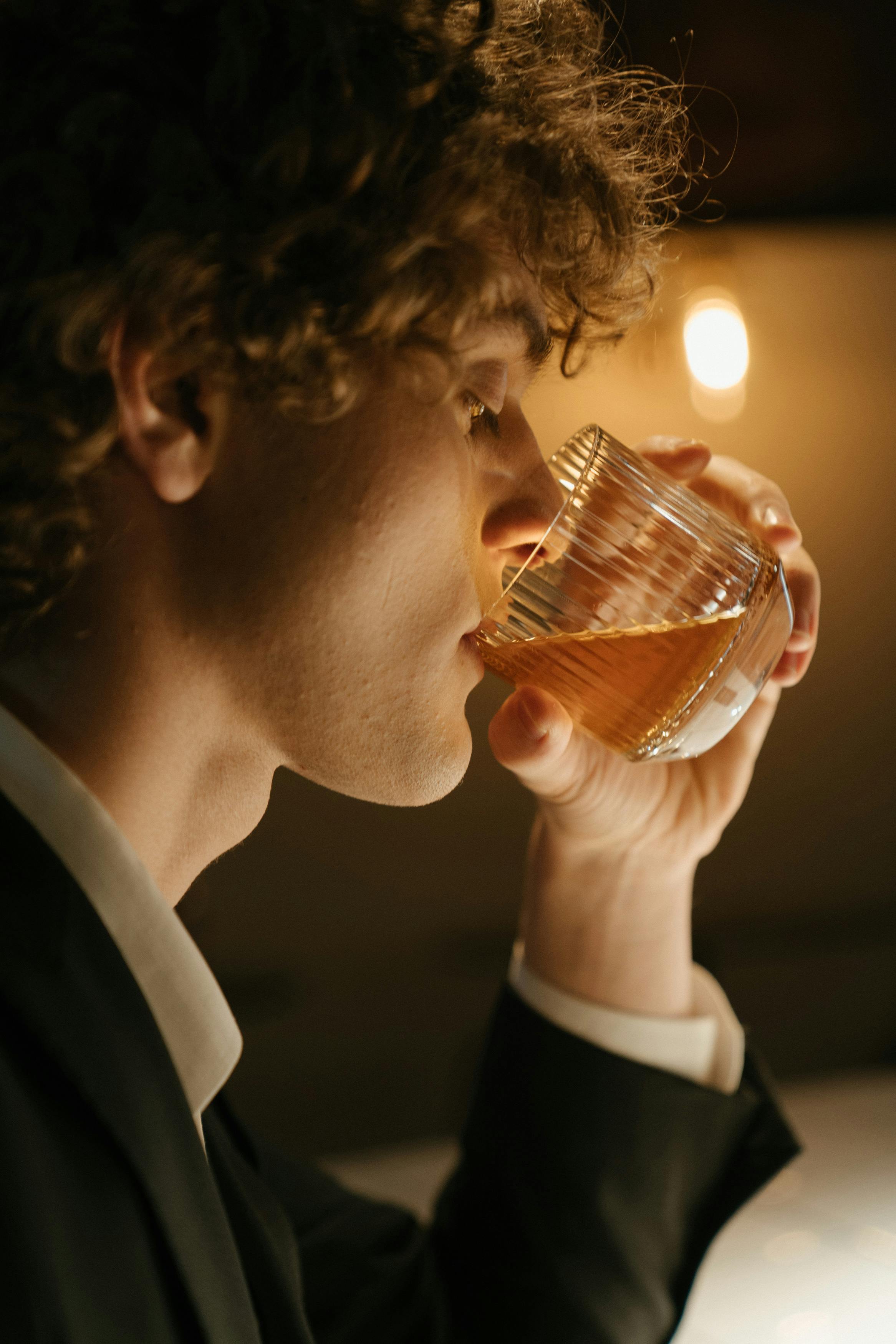 A man drinking from a glass | Source: Pexels