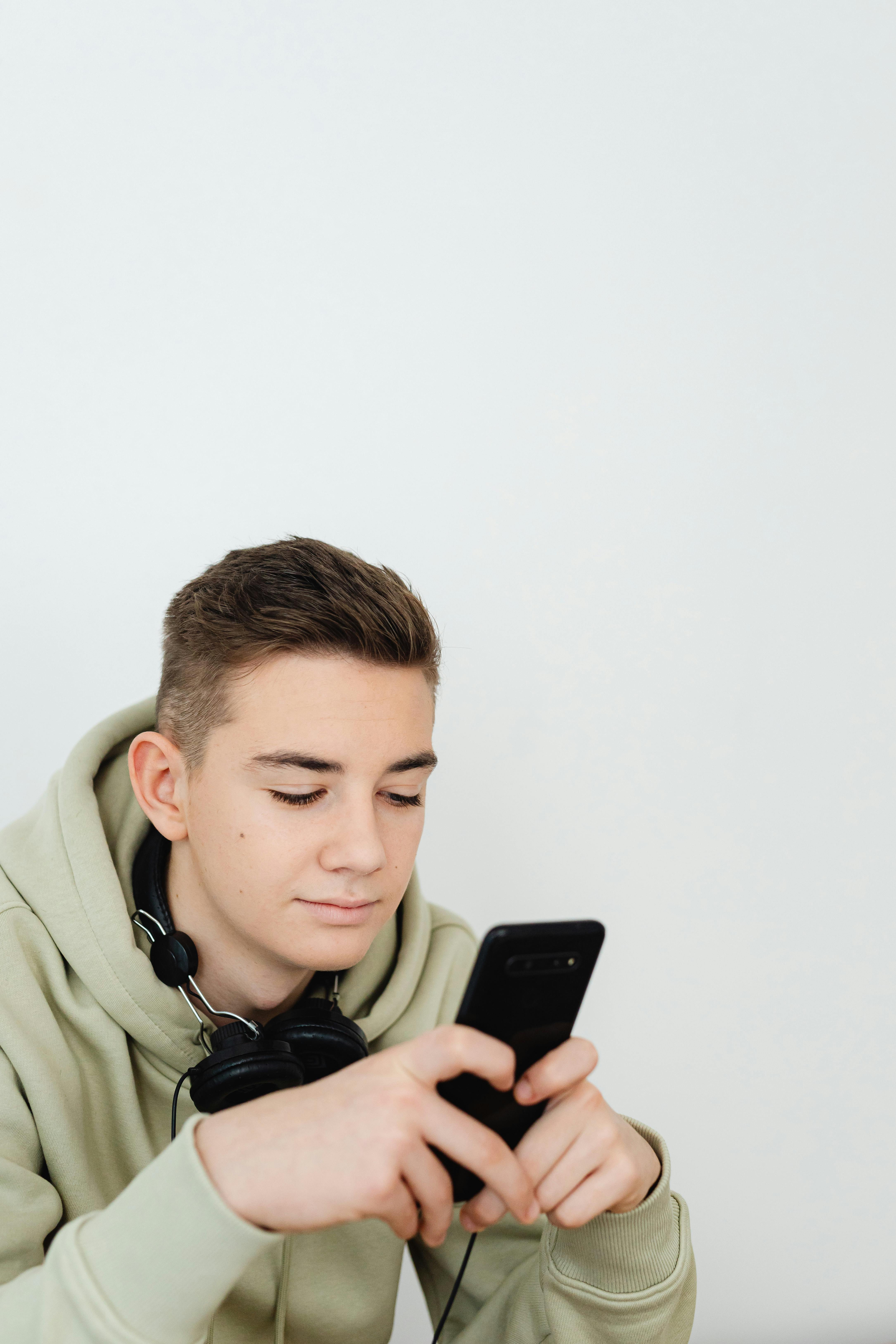 A teenage boy using a phone | Source: Pexels
