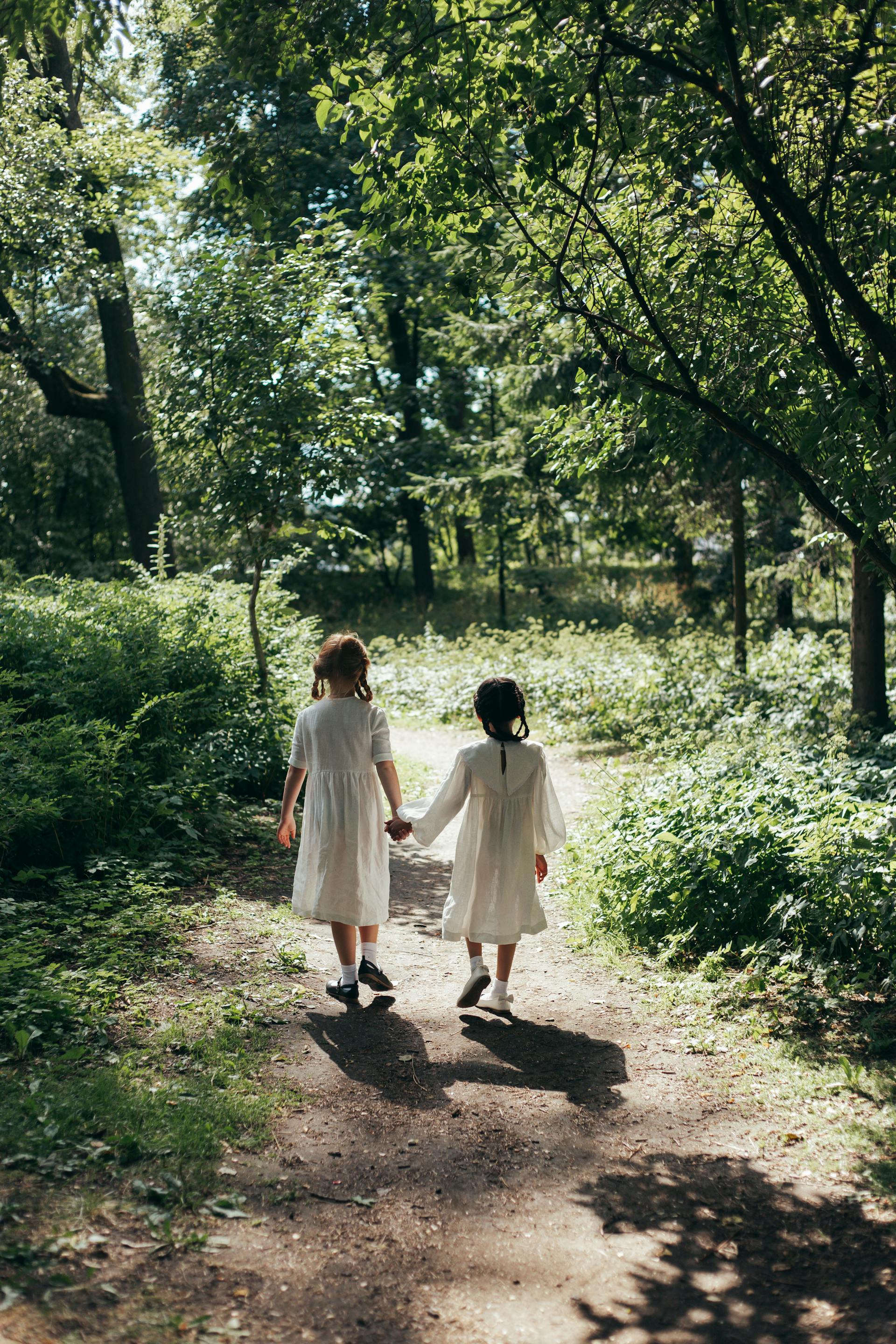 Little girls holding hands while walking | Source: Pexels