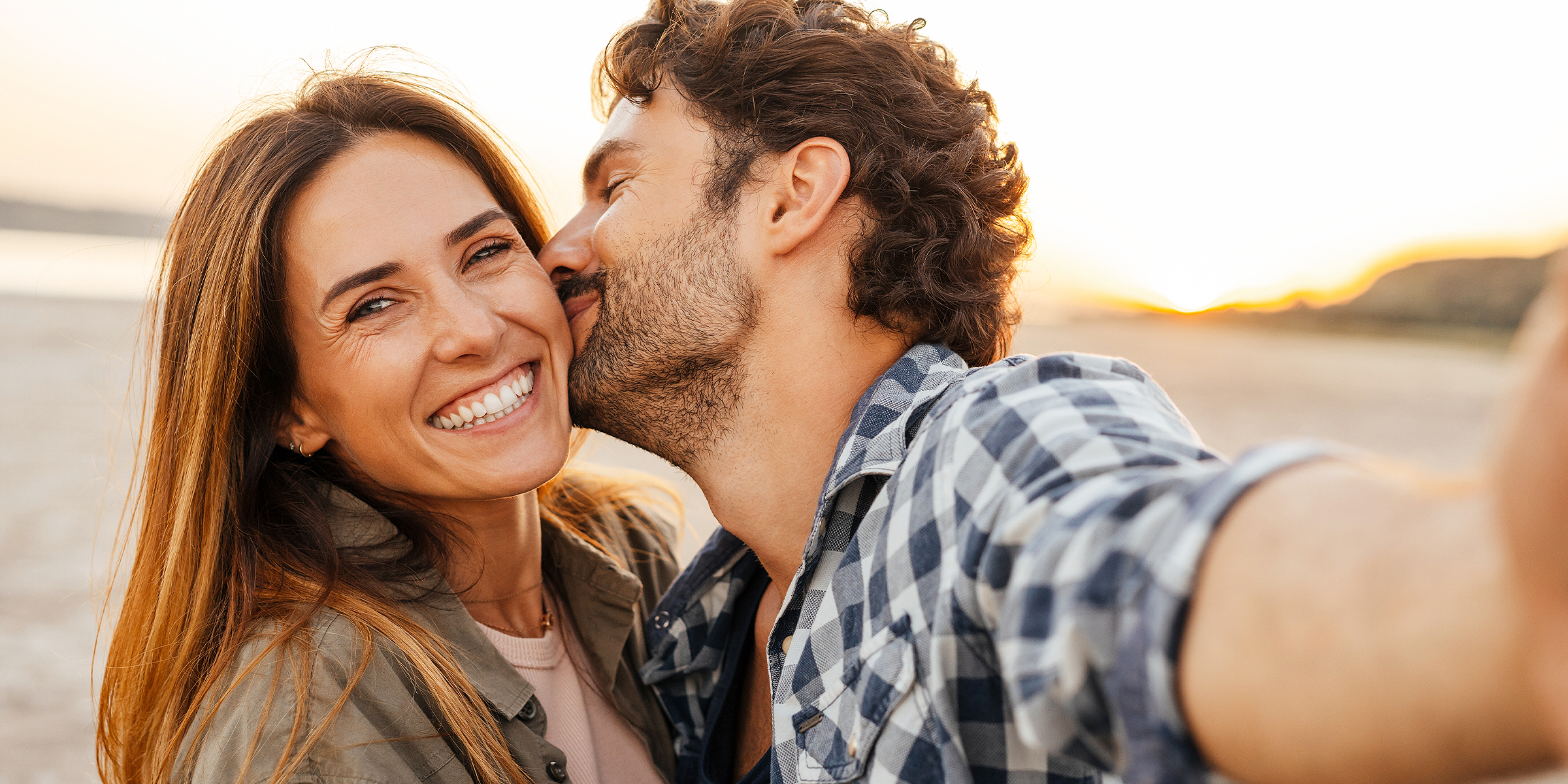 A man kissing a smiling woman on the cheek | Source: Shutterstock