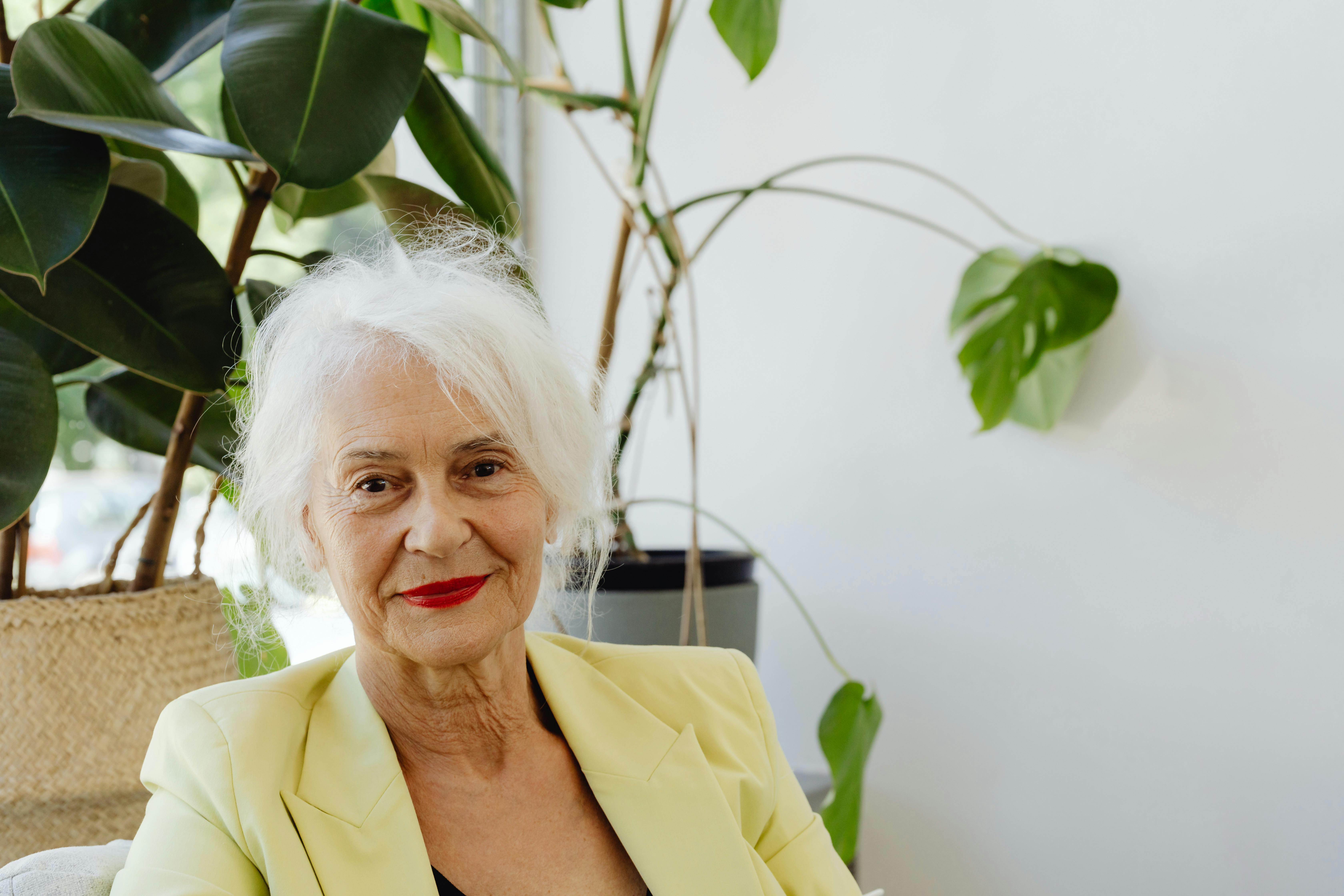 A smiling old lady wearing a yellow blazer | Source: Pexels