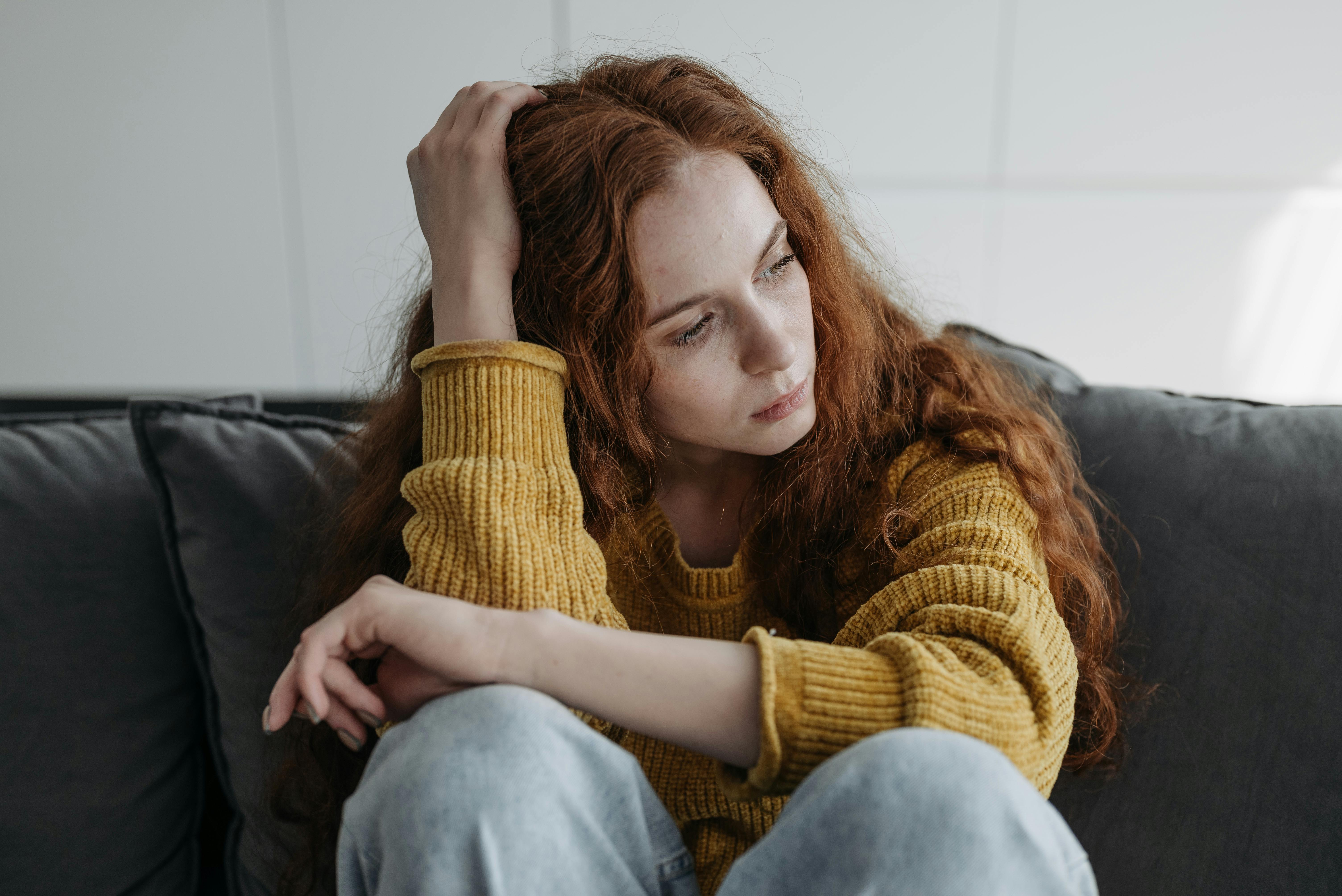 A woman sitting on a couch | Source: Pexels