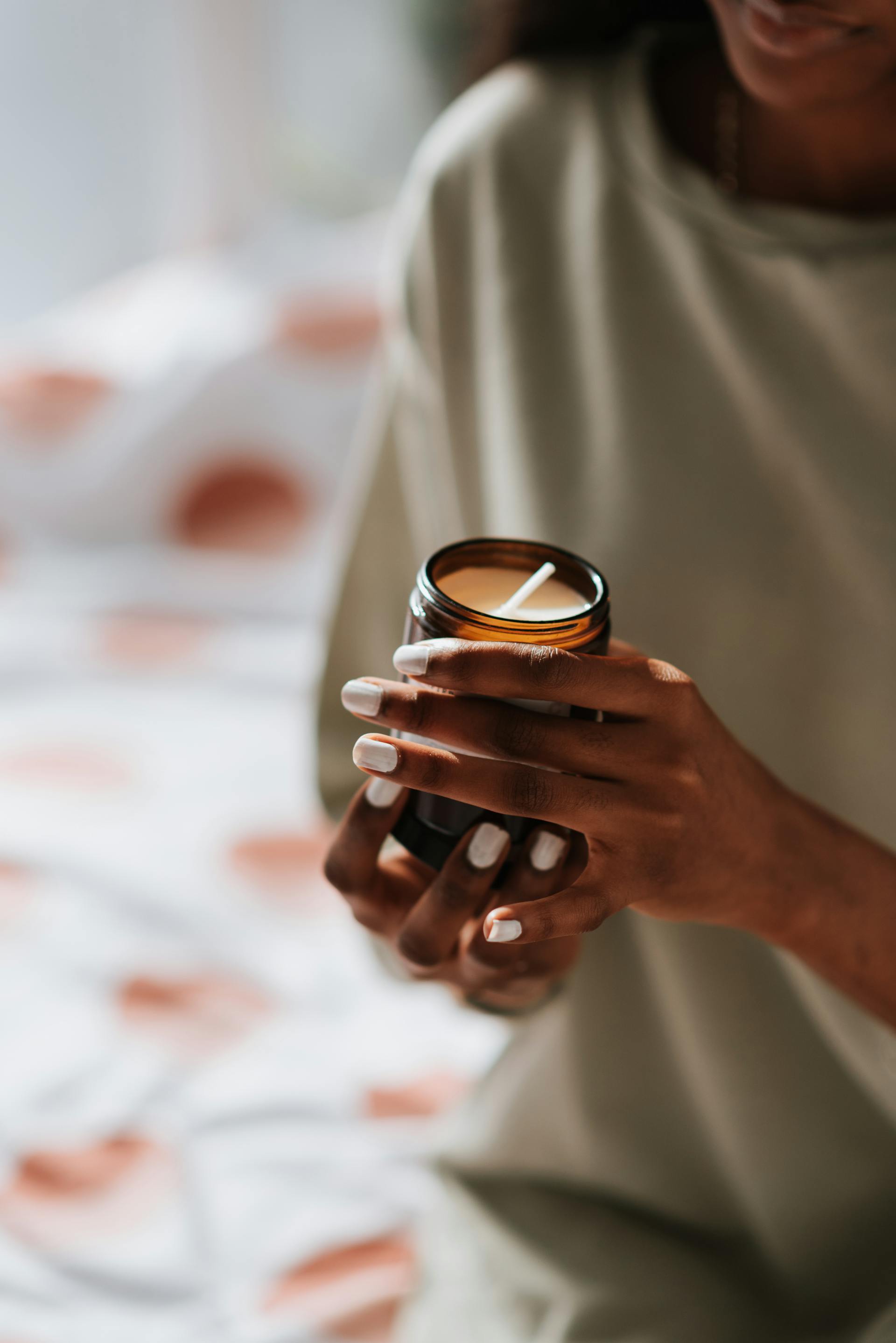 A woman holding a scented candle | Source: Pexels