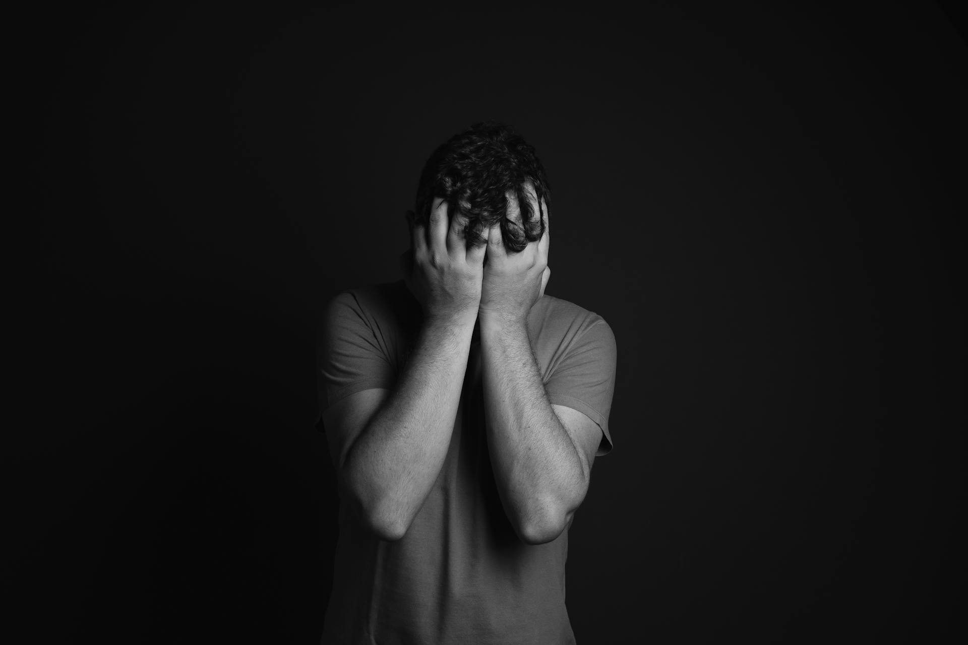 A man standing with his hands on his face | Source: Pexels