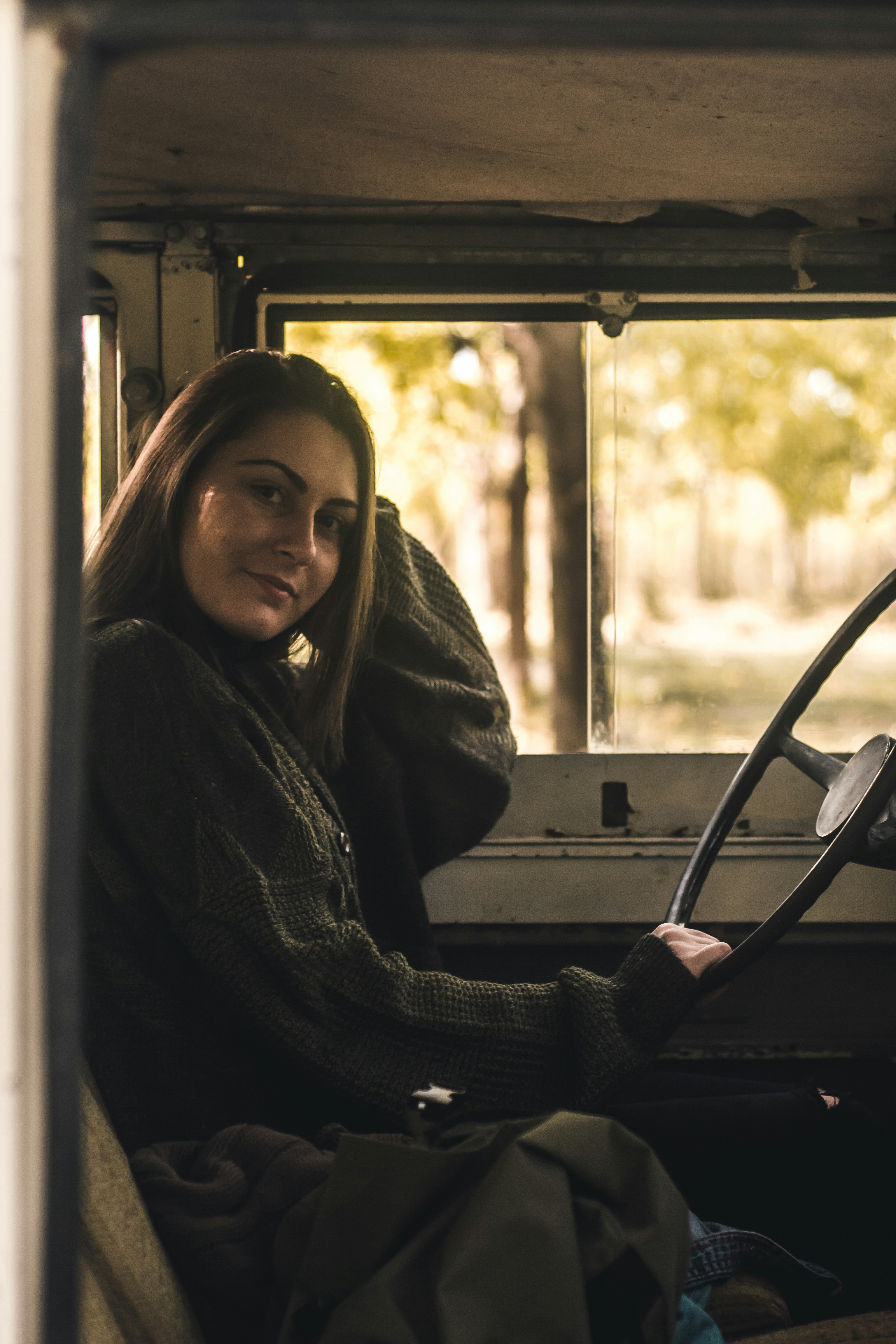 A smiling woman sitting behind a steering wheel | Source: Unsplash